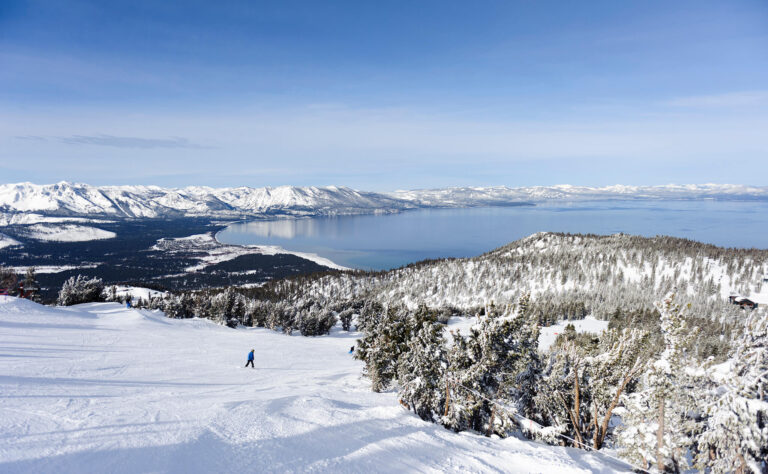 Skifahrer genießen von der Piste aus ein herrliches Winterpanorama und einen wunderschönen Blick auf Lake Tahoe.