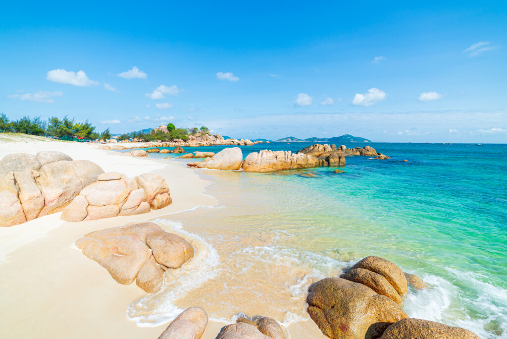 Wunderschöner tropischer Strand türkisfarbenes transparentes Wasser einzigartige Felsbrocken, Cam Ranh Nha Trang Vietnam Südostküste Reiseziel, Wüstenstrand menschenleer strahlend blauer Himmel