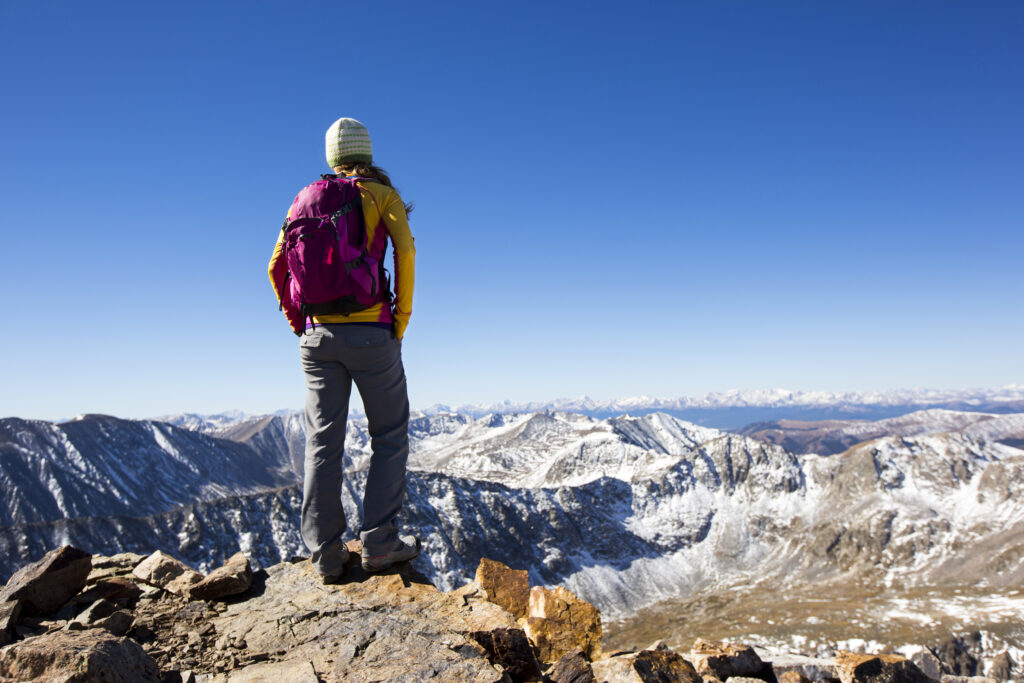Eine junge Frau besteigt den Gipfel eines 14.000 Meter hohen Berges in der Nähe von Breckenridge, Colorado.