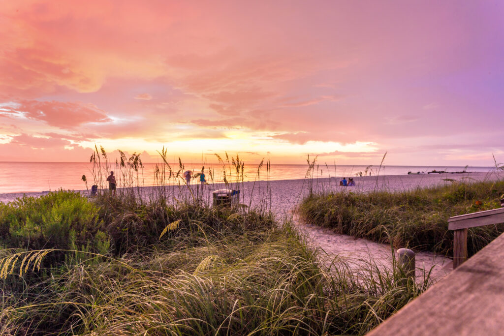 Die Sonne geht am Strand von Naples am Golf von Mexiko im Südwesten Floridas, USA, unter. Ein wunderbarer Aussichtspunkt, um den Sonnenuntergang zur blauen Stunde zu beobachten.